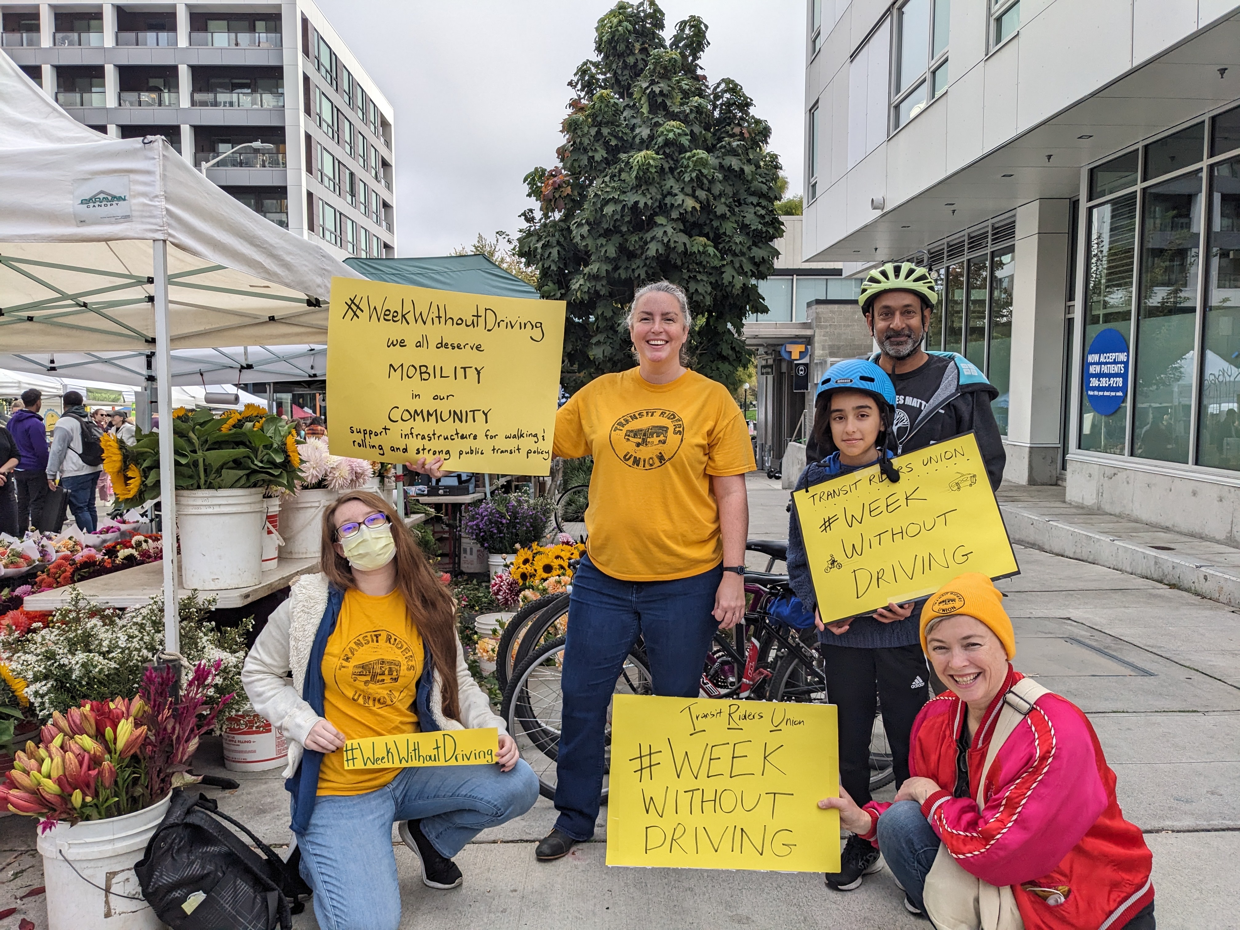 A group of people with yellow signs saying #WeekWithoutDriving