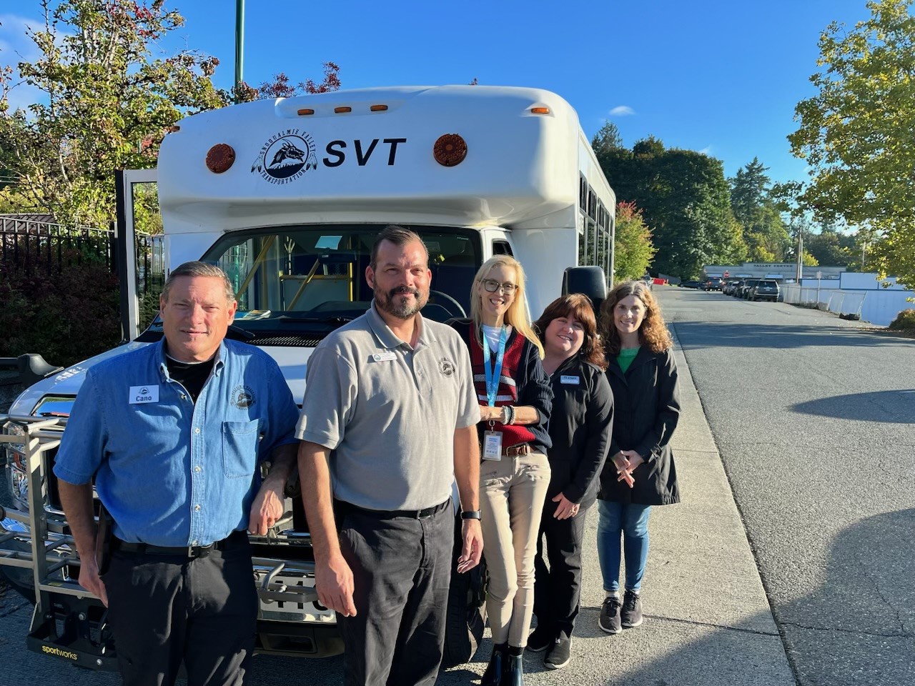 A group of people standing in front of a mini bus